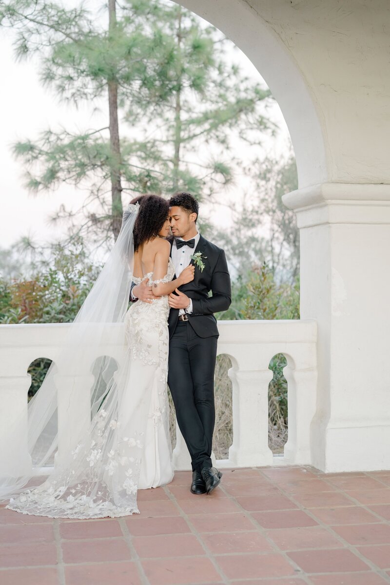 Destination wedding photography at Junipero Serra Museum in San Diego, captured by Felisha, a New England-based wedding photographer specializing in Boston, Rhode Island, and worldwide weddings. This intimate moment between a bride and groom showcases the emotional connection and elegance of a destination wedding.