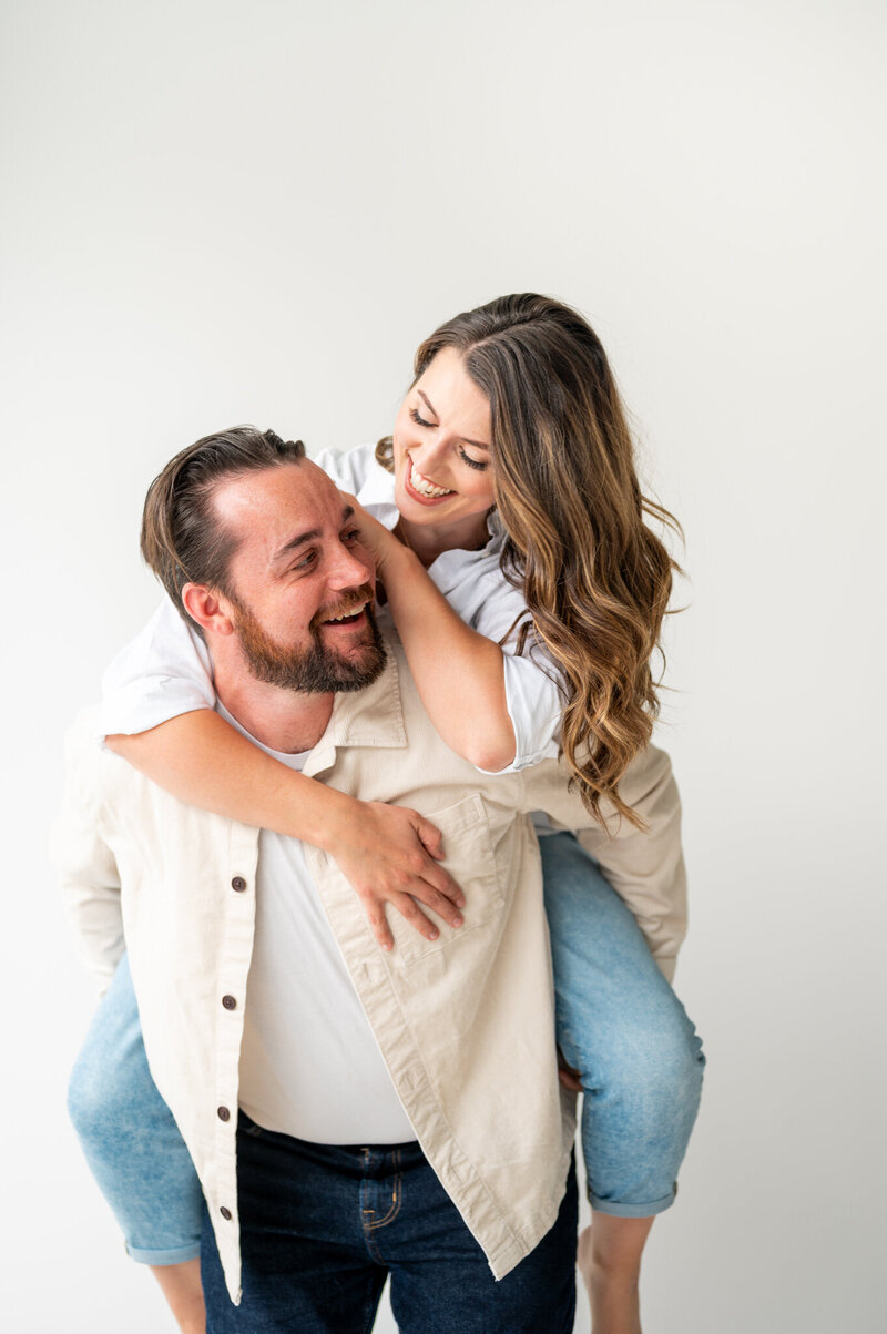 Reg and Kala are Raleigh's premier husband and wife photography team. In this photo, Reg and Kala are smiling at each other as Reg gives Kala a piggy back ride.