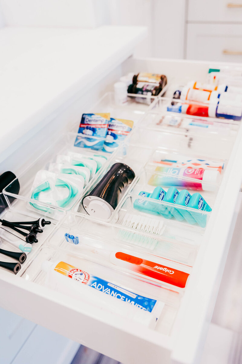 A bathroom drawer featuring neatly organized dental hygiene products