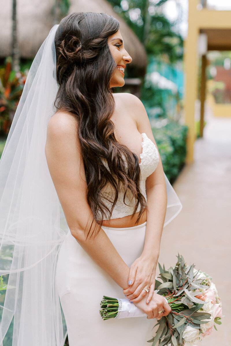 bride holding bouquet in a tropical setting