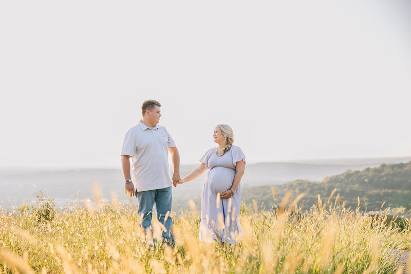 maternity photographer in madison al by whitney briscoe - couple standing in field holding hands