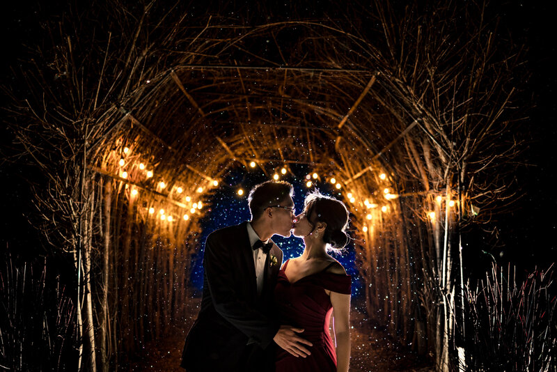 A Chinese wedding couple kissing under an arch of lights during a winter wedding in Toledo Ohio