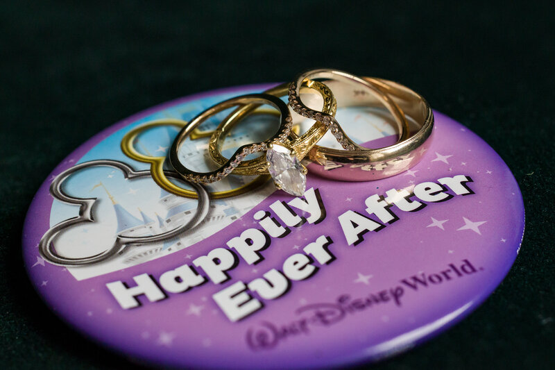 Close-up of wedding rings placed on a Disney pin, adding a playful and personal touch to the wedding details.