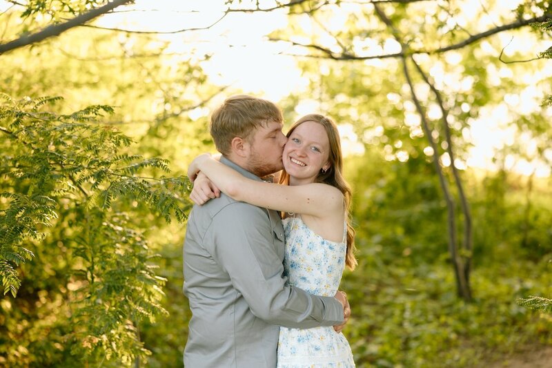 couple embraces for engagement photos in kansas city missouri