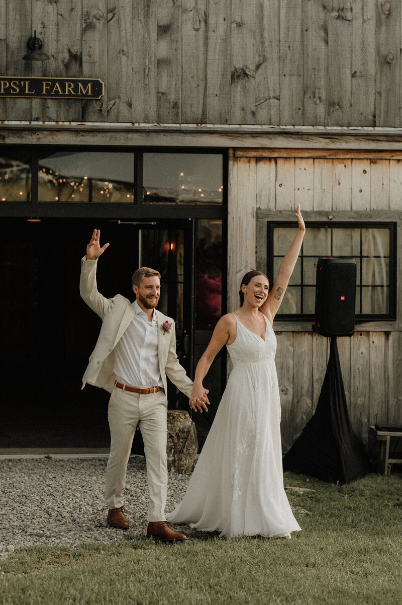 Couple celebrating their Maine Wedding with arms up in the air