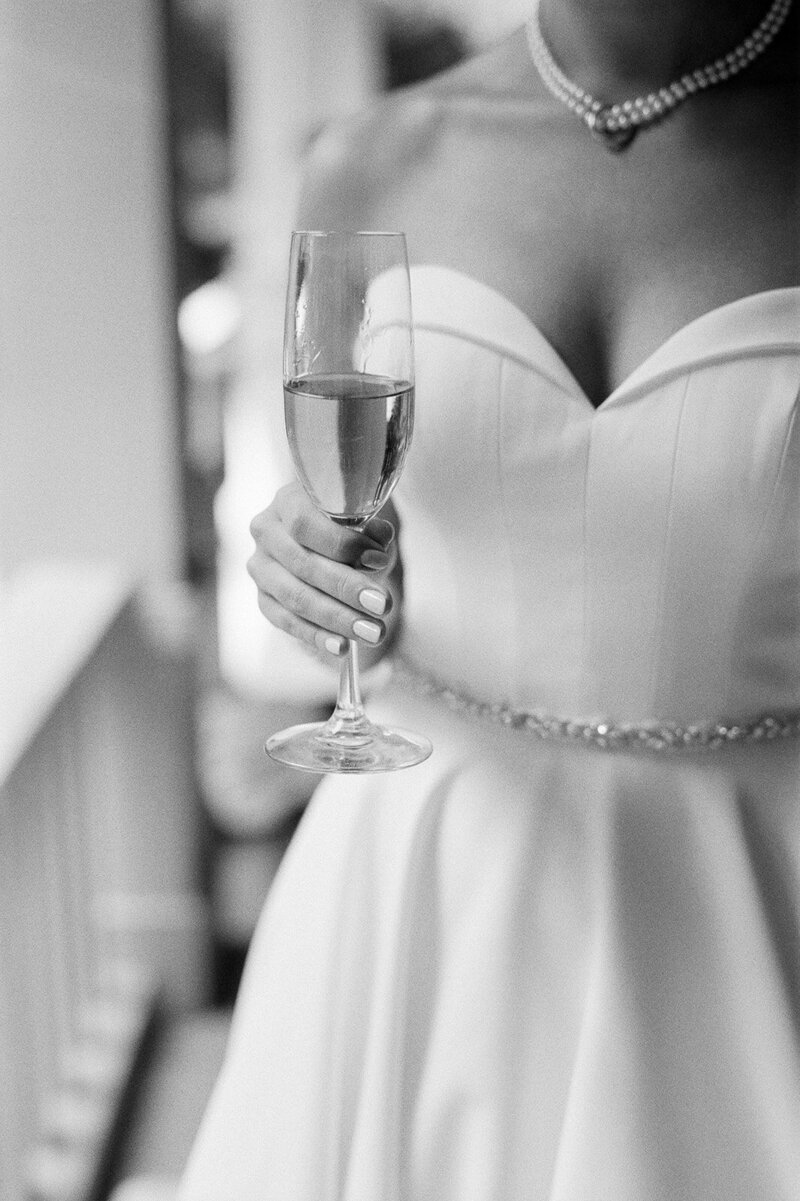 bride holding a champaign glass at the ausable club