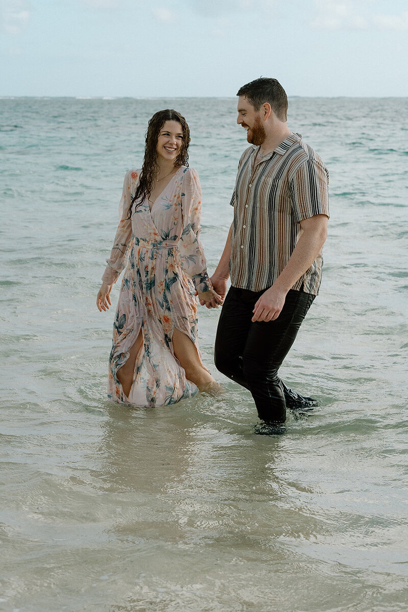 couple walks in ocean in Hawaii