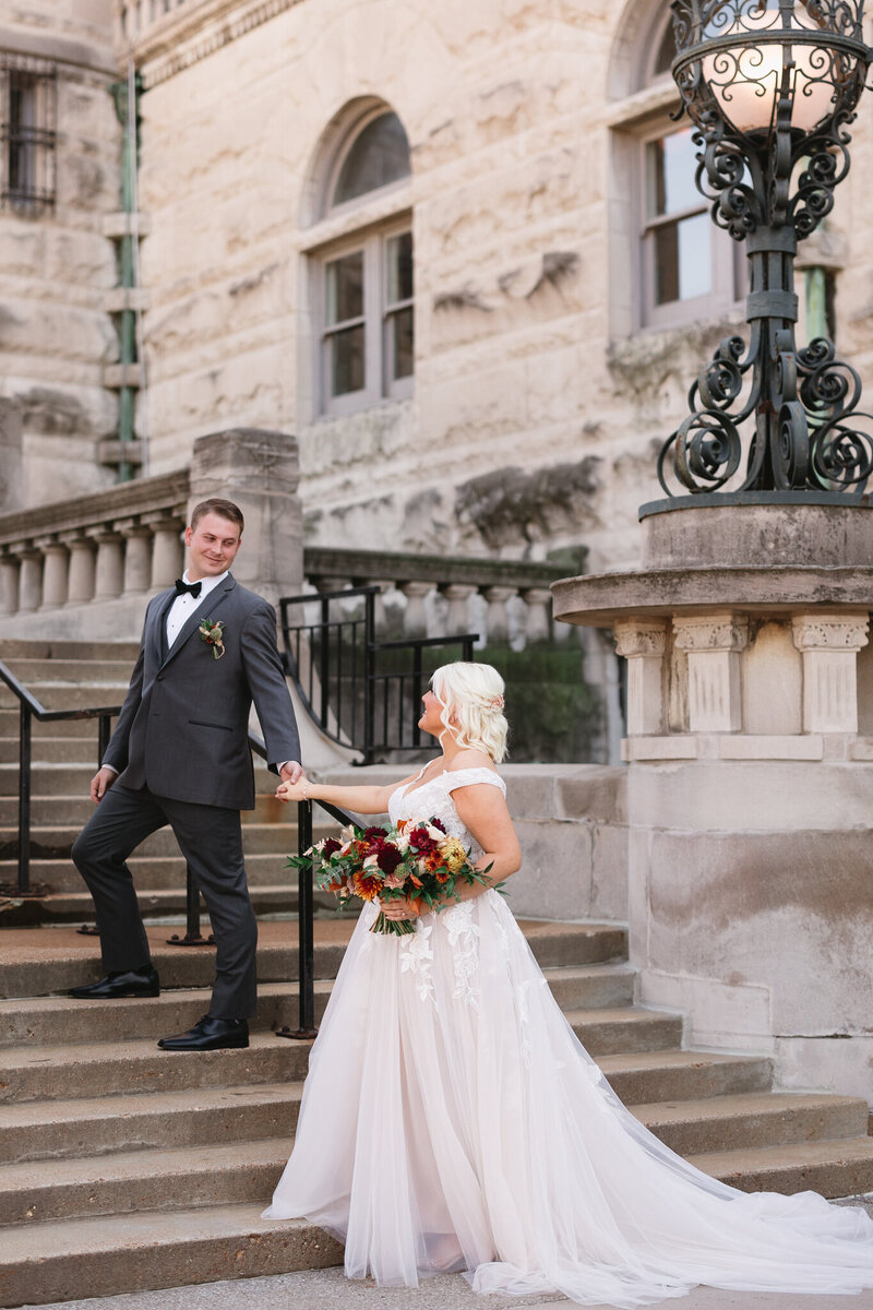 Bride and groom walking in front of St. Louis Art Museum