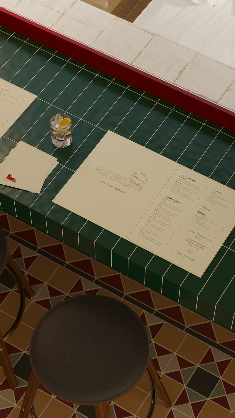 LUCCA Italian Sandwich Shop printed menu on green tiled counter with glass of lemon water, highlighting timeless design and brand identity.