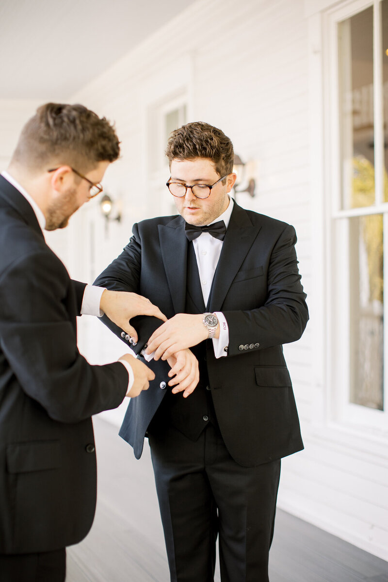 Groom adjusting tie in the groom’s suite at The Allan House before the ceremony