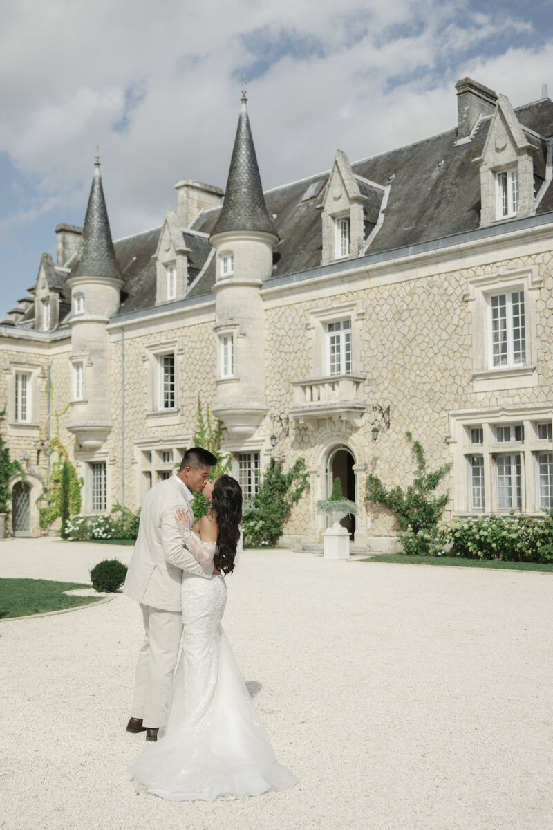 bride and groom in front of chateau in France