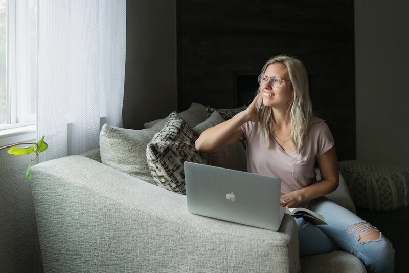 Mother is looking at her youngest son, who is held by his father, lovingly while the oldest boy is looking at the camera with a smile