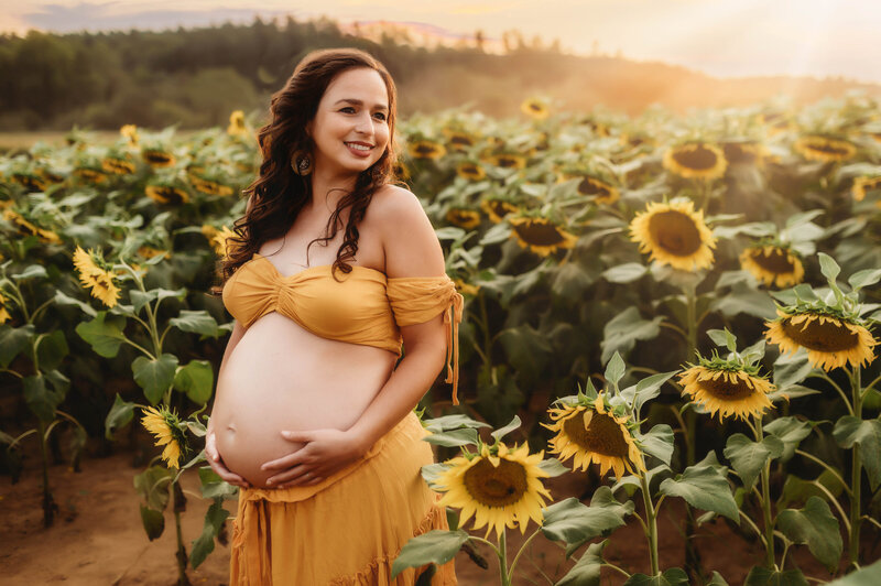 Expectant mother poses for Maternity Photos in a Sunflower field in Charleston, SC.