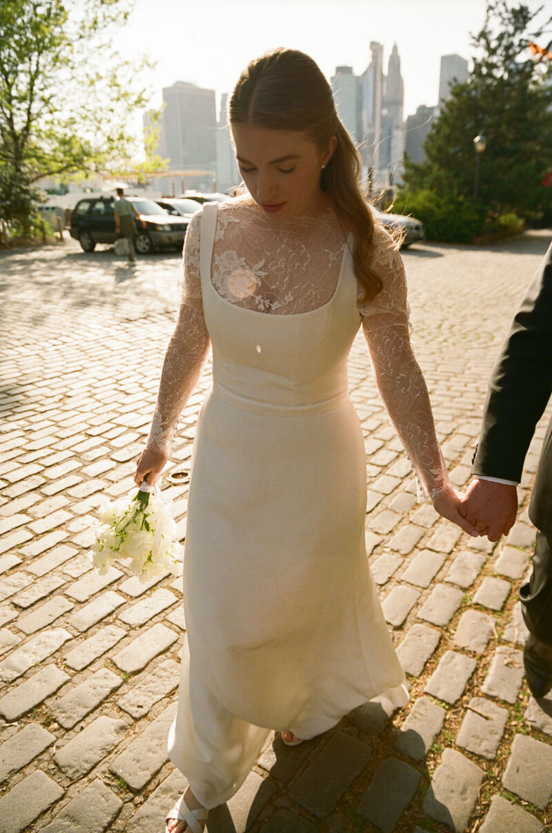 Carley walking hand in hand on a cobblestone street