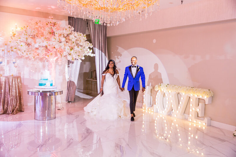 Bride and groom make their grand entrance into their wedding reception to cheers and celebration.