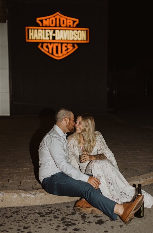 bride and groom sitting by Harley Davidson