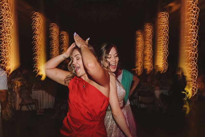 Bride and friend dancing during reception