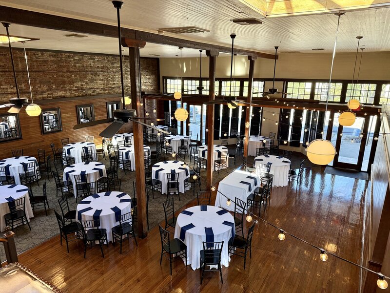Immense sunlight coming into te Palafox Wharf Wedding Venue a place in Pensacola FL for weddings with white linens and navy napkins, gulf coast celebration, wedding venues, pensacola fl, historic charm, modern amenities, event spaces, customization, downtown Pensacola, romantic venue, all-inclusive venue, architectural details, Gulf Coast wedding