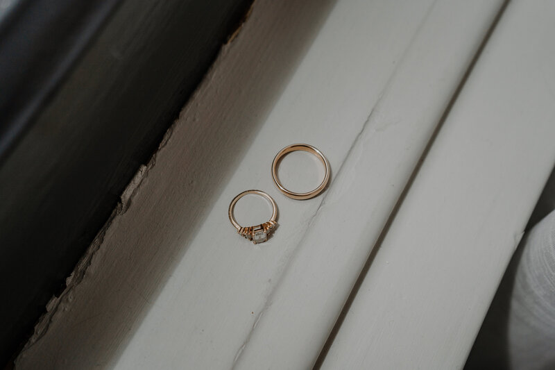 Two gold rings on a white window sill