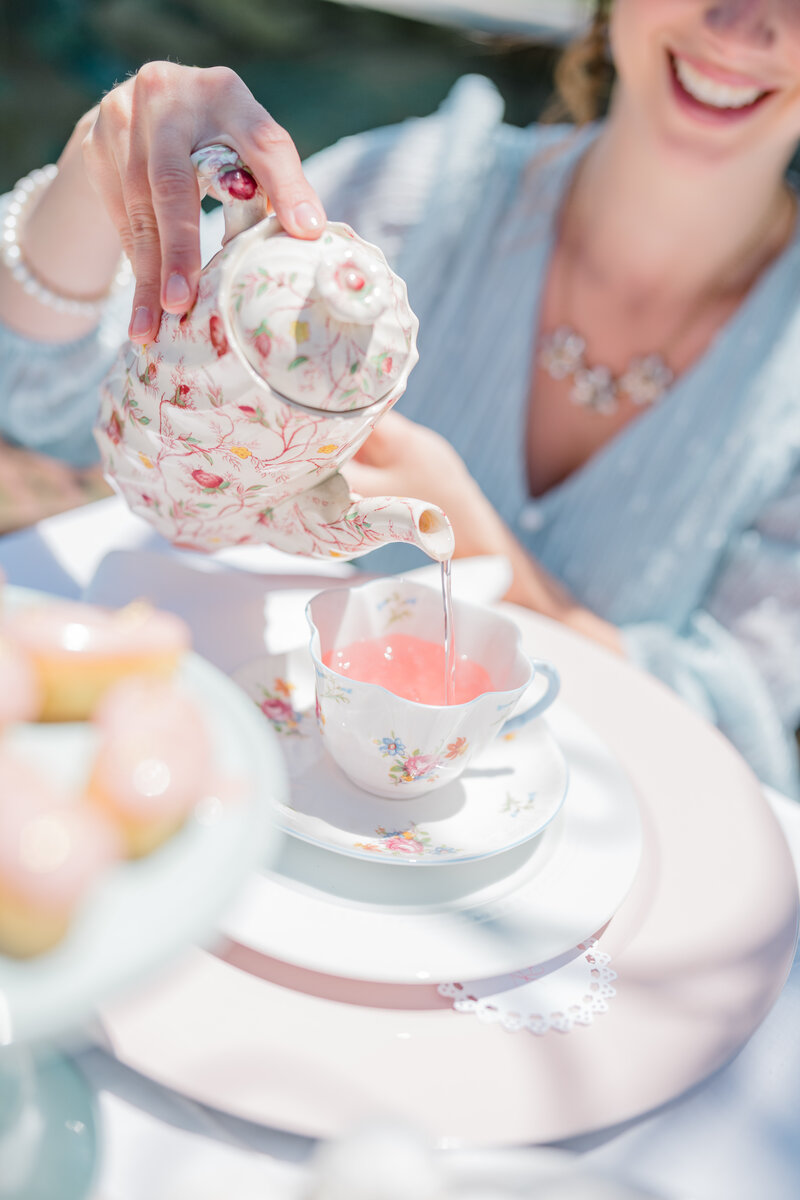 woman pouring a cup of tea at tea party