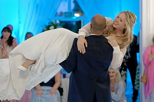 groom holding his bride in his arms in the middle of their first dance