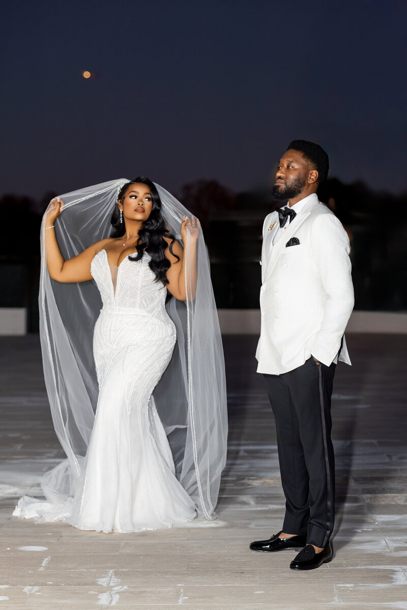 woman and man holding veil on rooftop