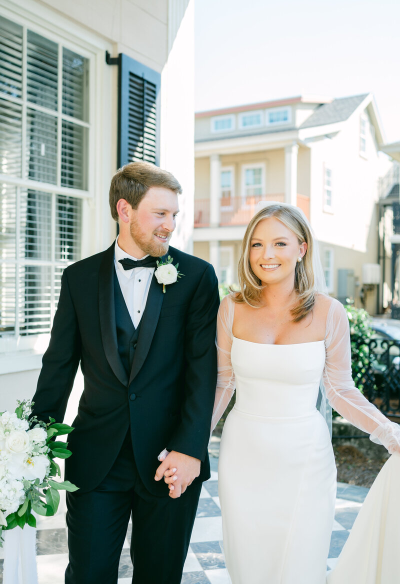 bride and groom kissing as veil blows in the wind