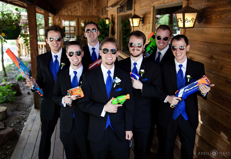 Playful groomsmen portrait with water guns at Wild Basin Lodge in Allenspark