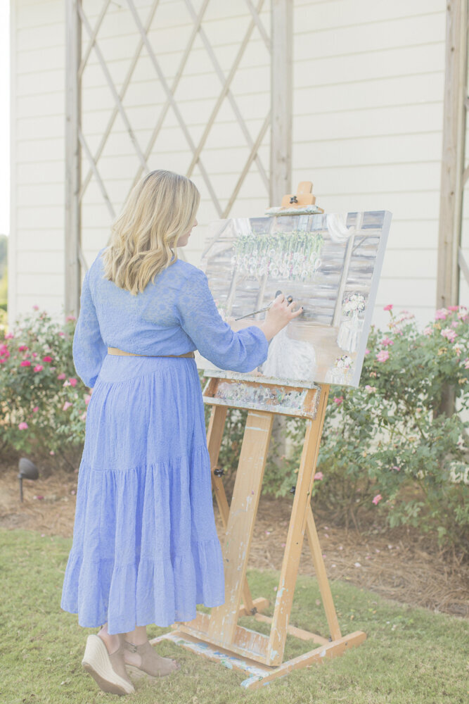 Miriam painting a live wedding painting outside of a church