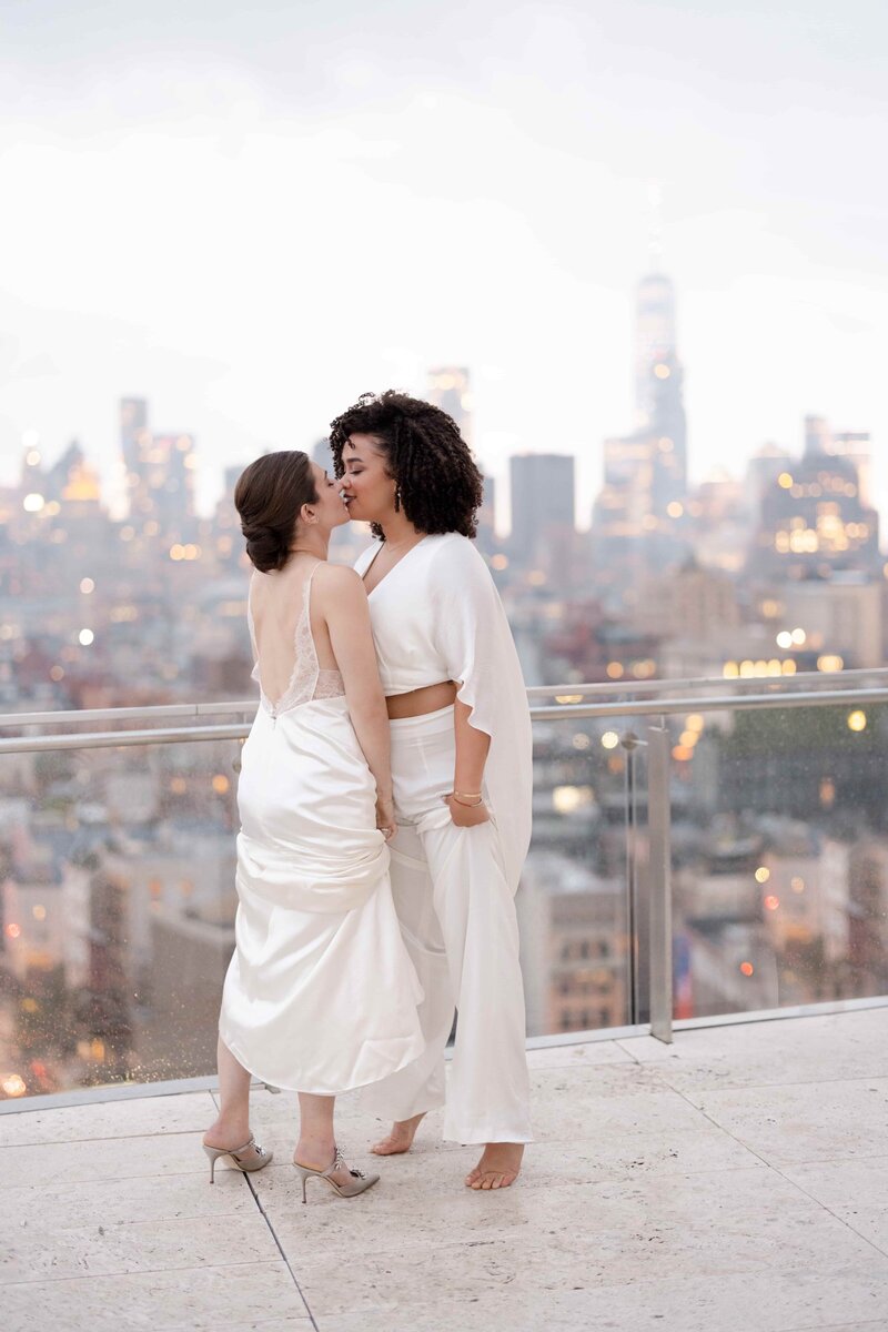 Two Brides Kissing on Rooftop in White Gowns