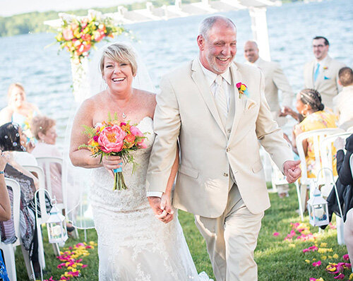 just married couple walk hand in hand up the aisle