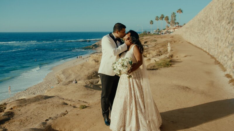 Indian wedding couple kissing at the beach
