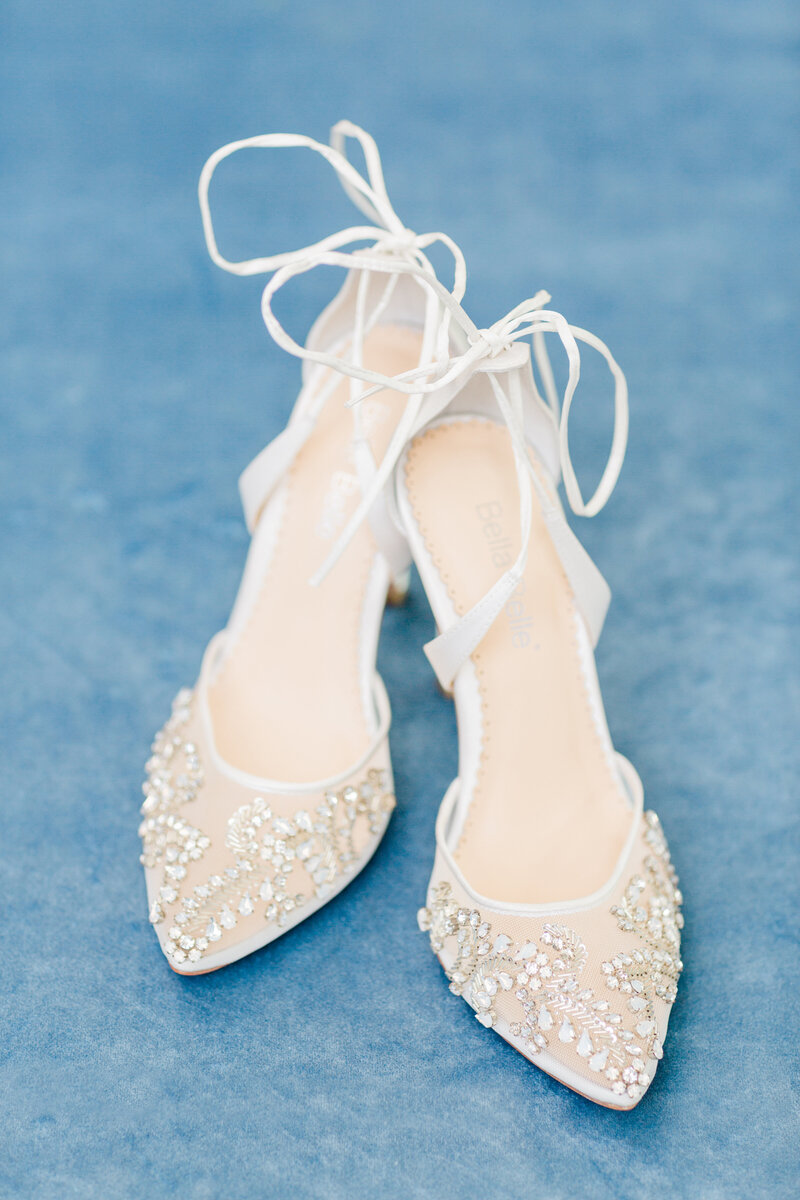 Delicate lace and crystal details bring a refined touch to this bridal shoe flat lay.