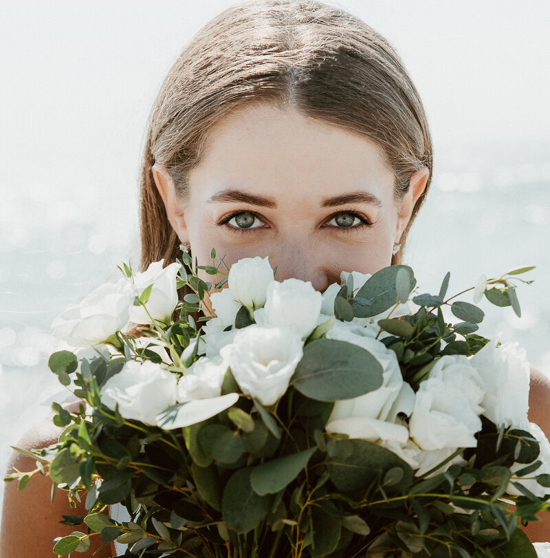 Bride holding bouquet up to her face at her Malibu elopement