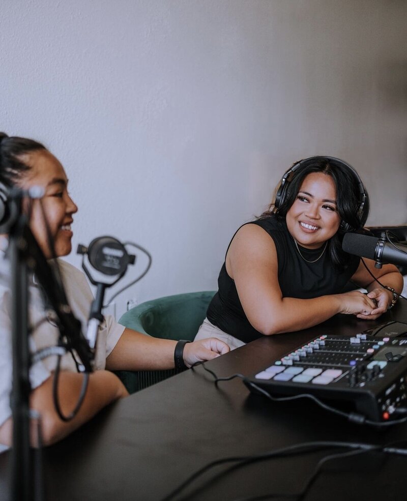 2 girls recording a podcast with recording equipment