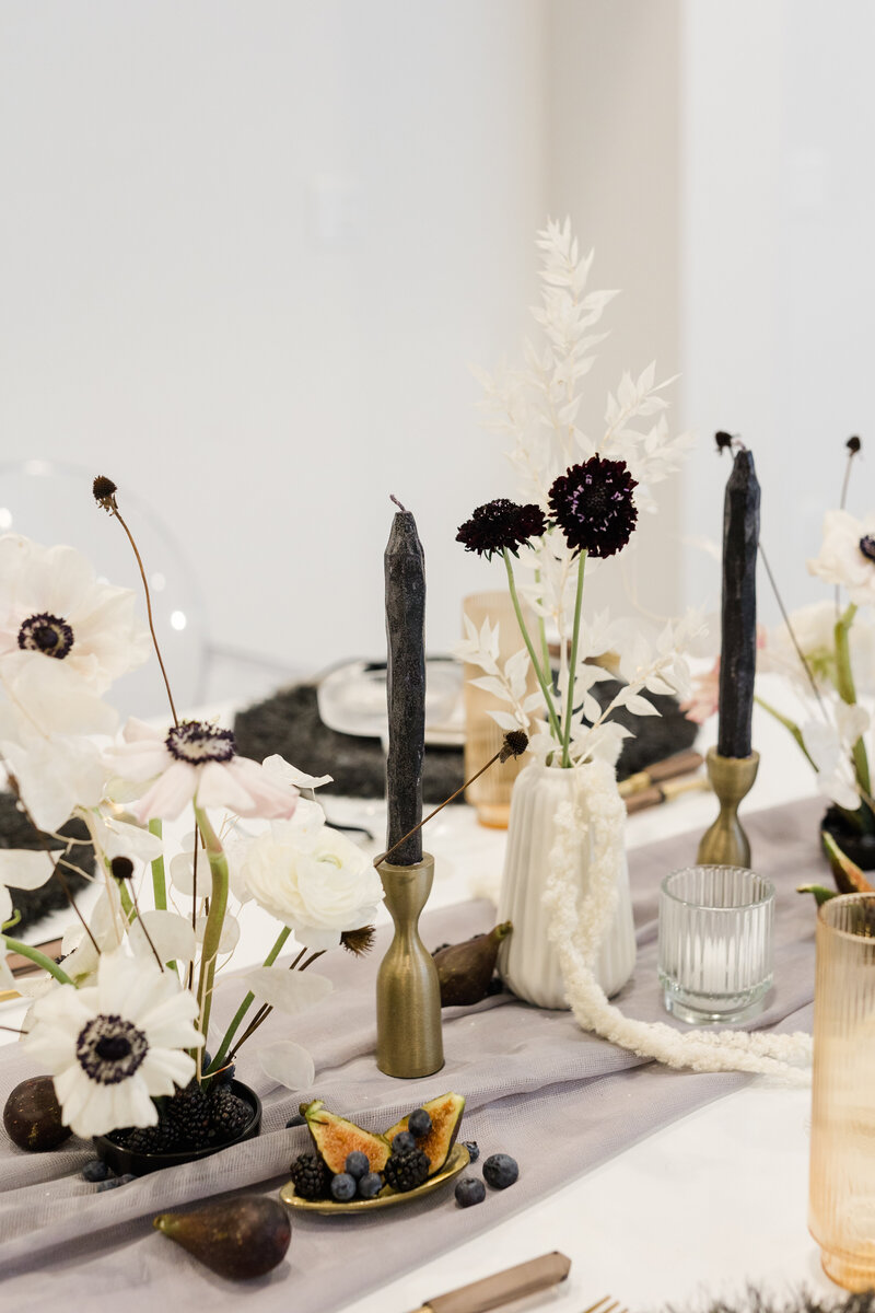 modern tablescape with white and black florals and black textured taper candles with gold holders
