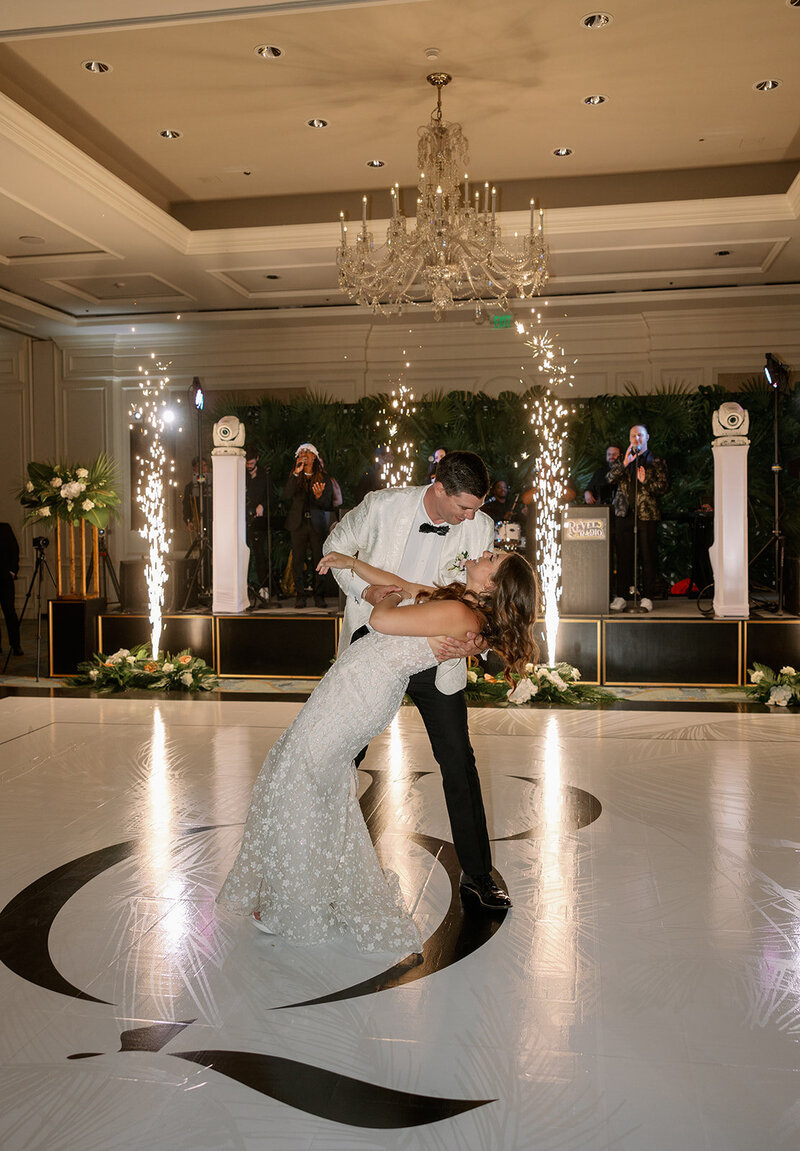 Couple enjoying their first dance at their indoor reception at The Ritz Carlton, Amelia Island. With a monogram on the dance floor wrap, cold sparks and a 17 piece band, this moment was perfectly executed by designer and wedding planner, The Eventful Gals. 