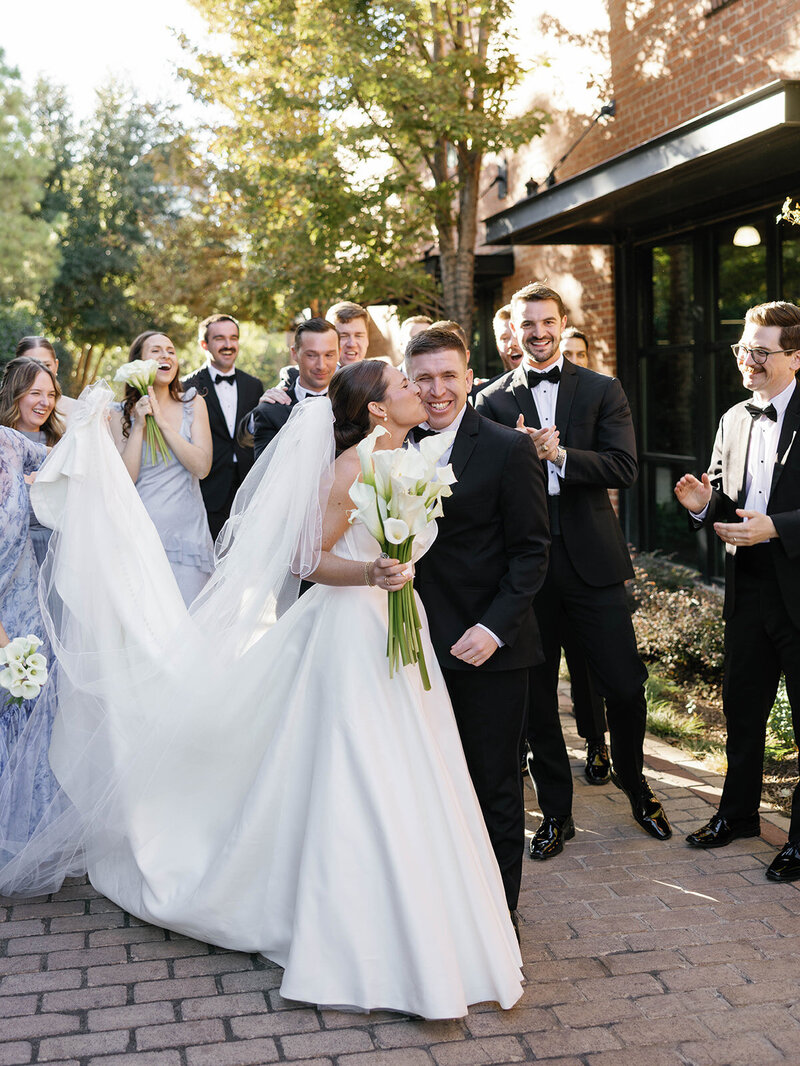 Reflection of a bride and groom walking together, captured through glass in timeless black and white.