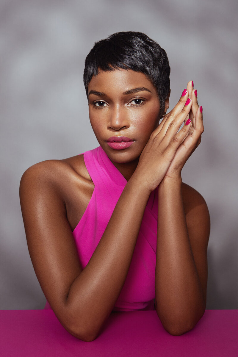 Shae in a vibrant beauty shot, wearing bold pink makeup and an expressive pose, captured by Ylva Erevall.