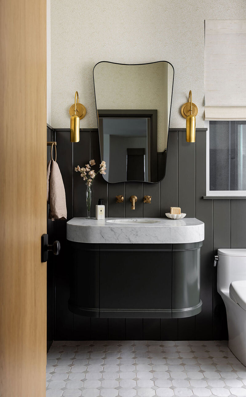 Modern bathroom featuring marble countertops and neutral-toned finishes
