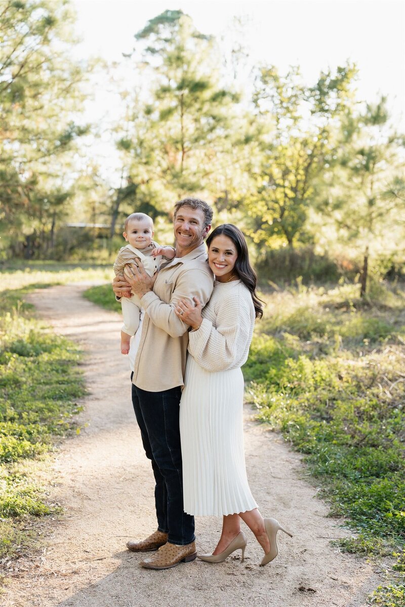 Family photo of parents swinging son and father holding baby