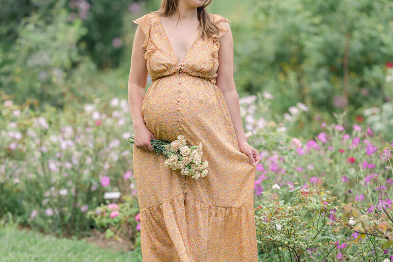 Maternity photos at Bartram Gardens. Pregnant woman holding flowers.
