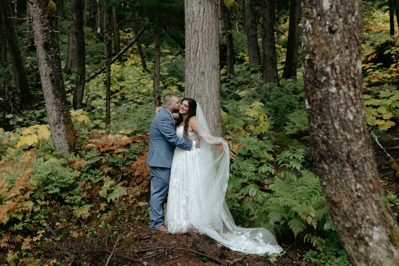 A couple standing together holding a bouquet of flowers after their wedding ceremony. 