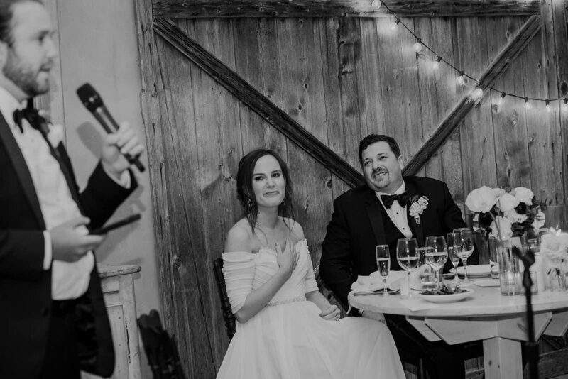 A person giving a toast next to a newlywed couple
