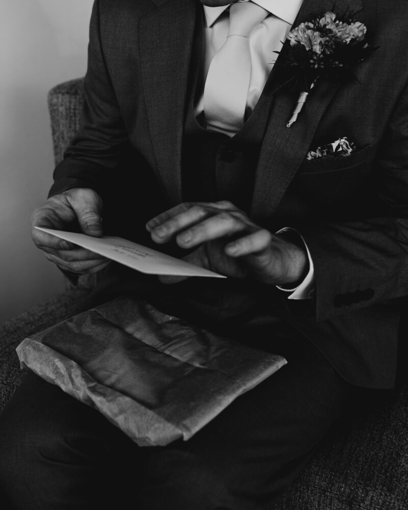 groom opens brides gift on their wedding day