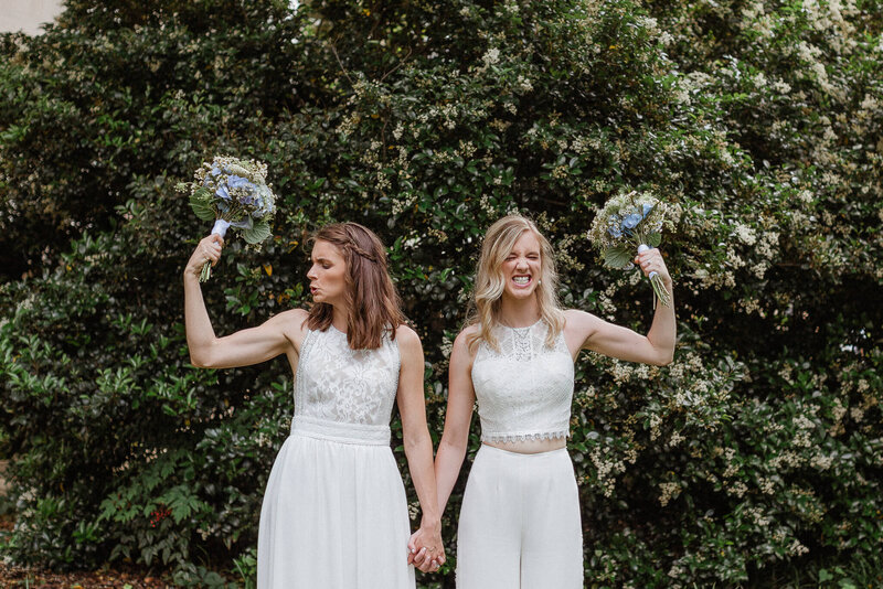 LGTBQ couple flexing their muscles on their wedding day.