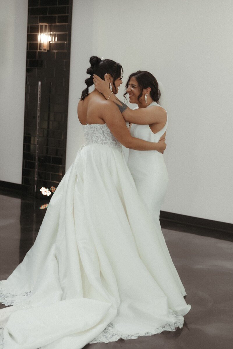 two brides smiling at wedding