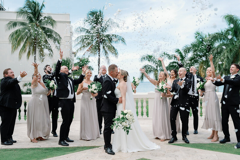 Married couple celebrates with wedding party and confetti