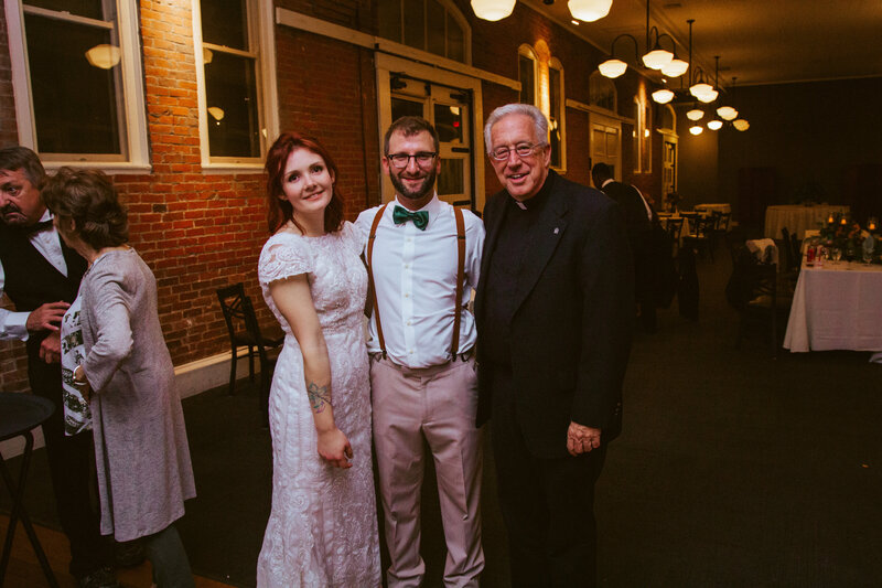 bride and groom posed with man