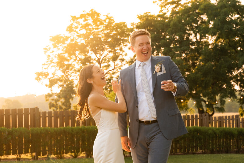 a newlywed couple laughing together at golden hour in central new jersey